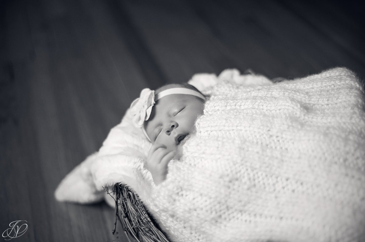 newborn in basket yawning