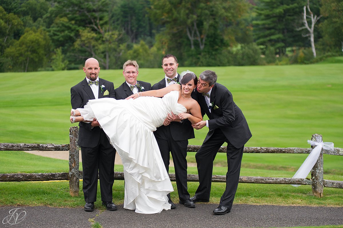 fun shot of groomsmen holding bride up