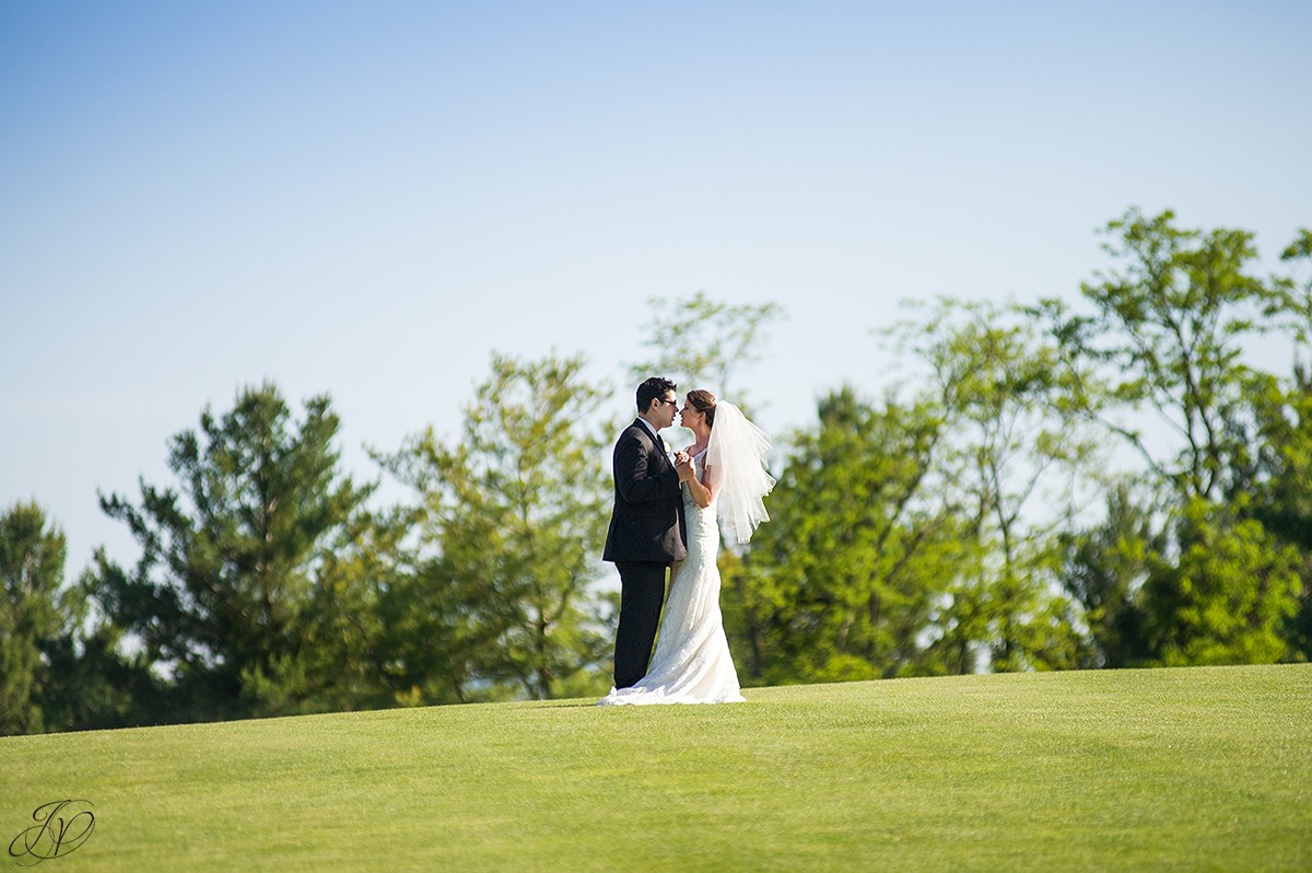 bride and groom kissing golf course photo