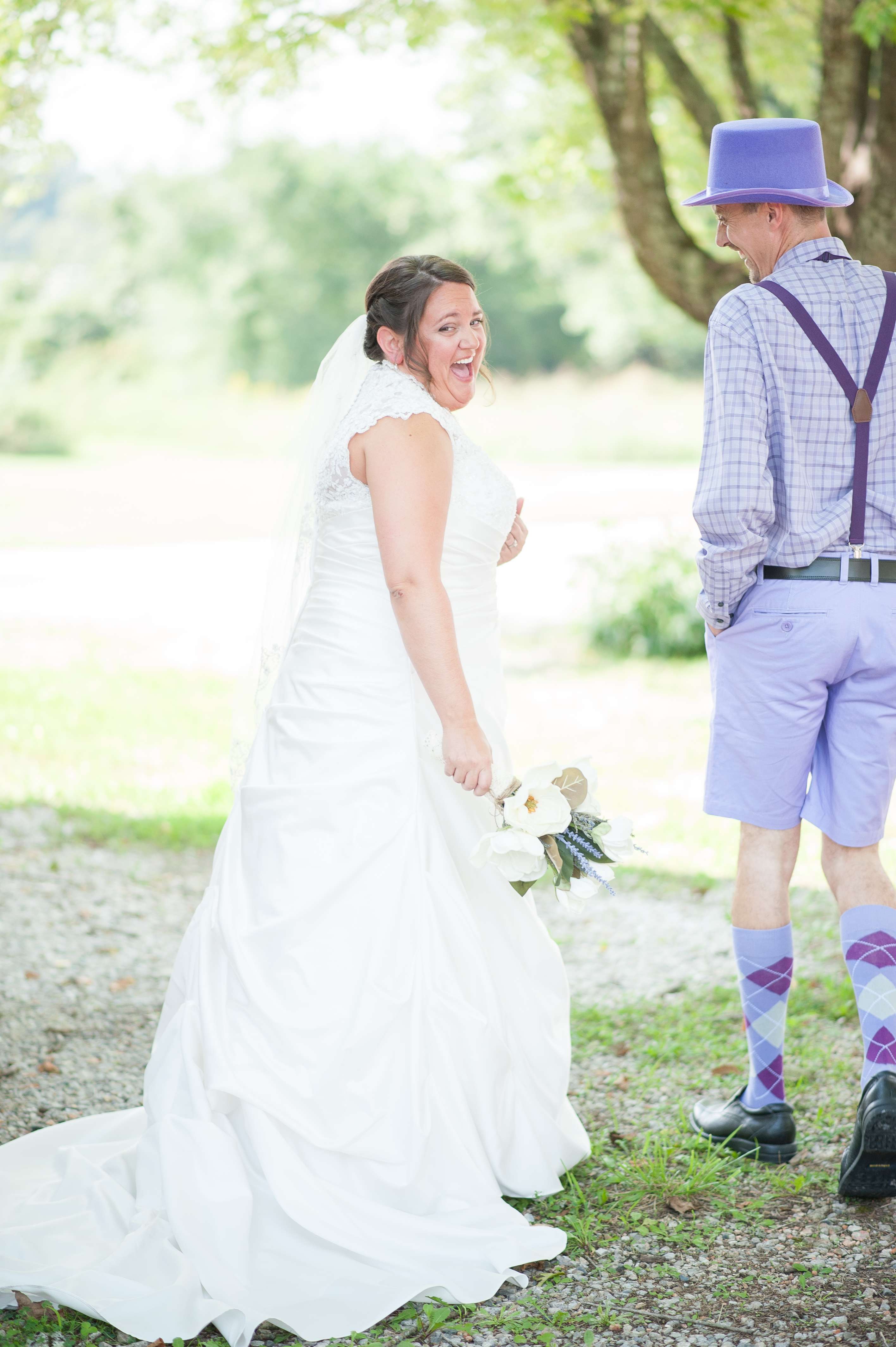 Bride laughing and being surprised by her ushers on her wedding day.