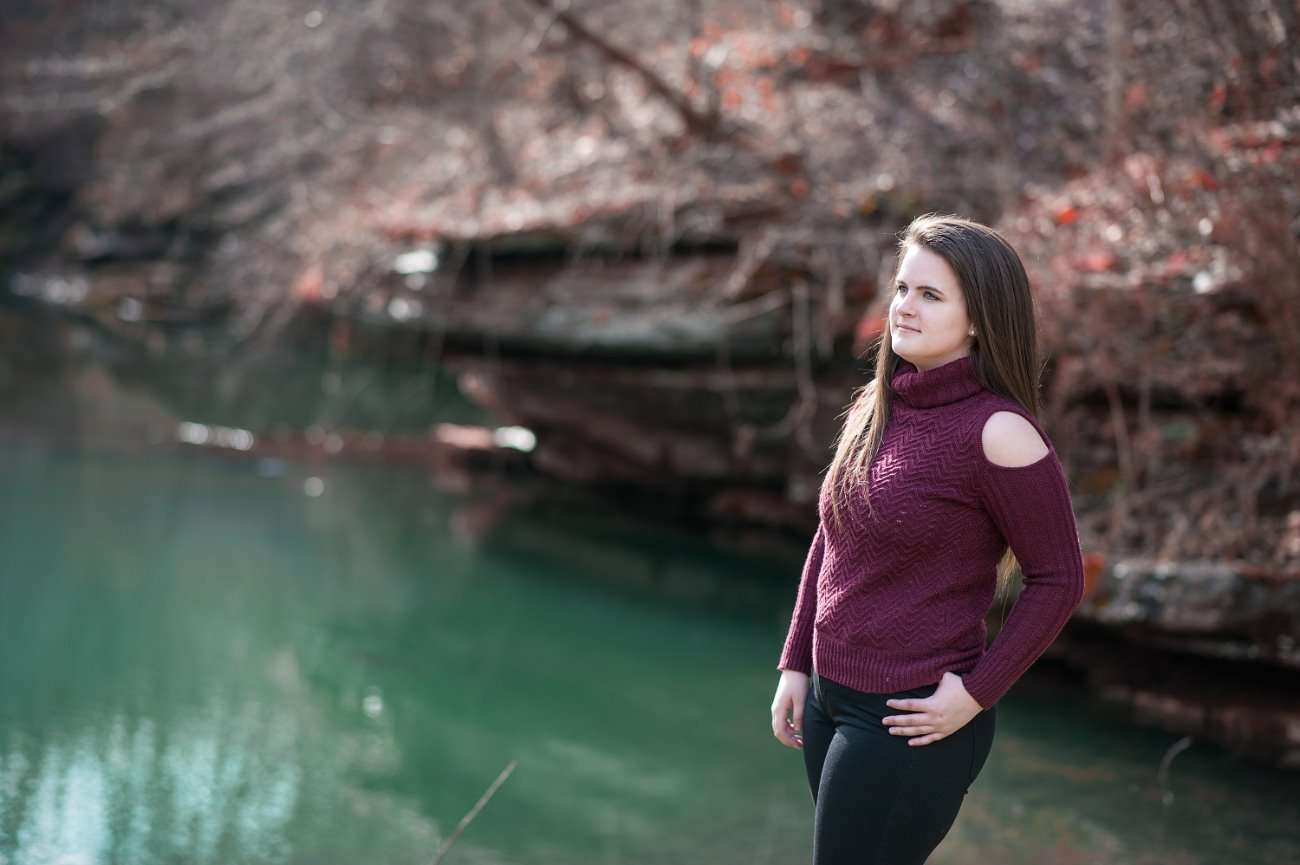 senior girl standing in front of water at Dogwood Canyon