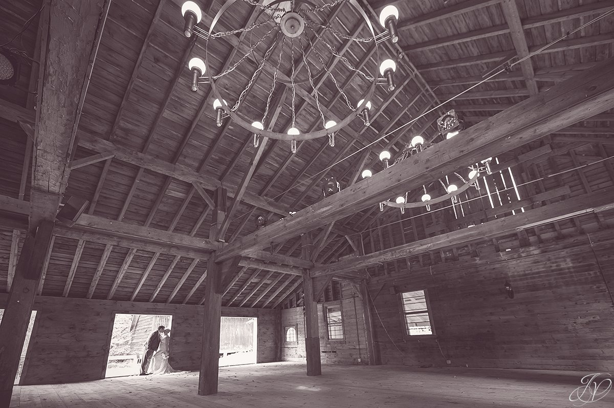 unique black and white photo of bride and groom in barn