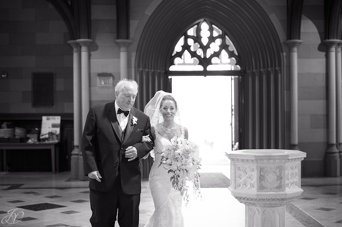 father walking daughter down the aisle at church black and white