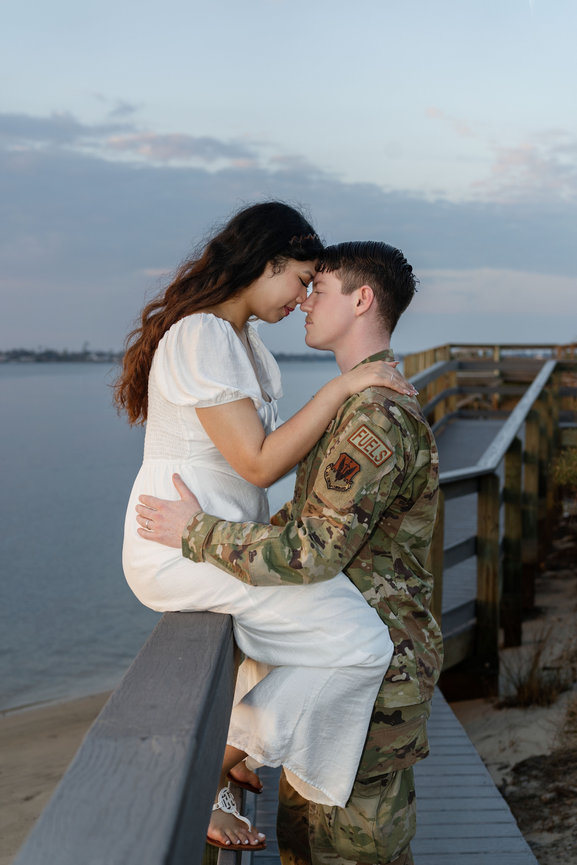 Senior Girl in white dress standing next to a bee mural