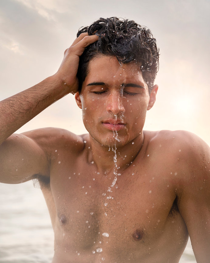 Male boudoir dripping with water outside on beach in St. Petersburg, Florida.
