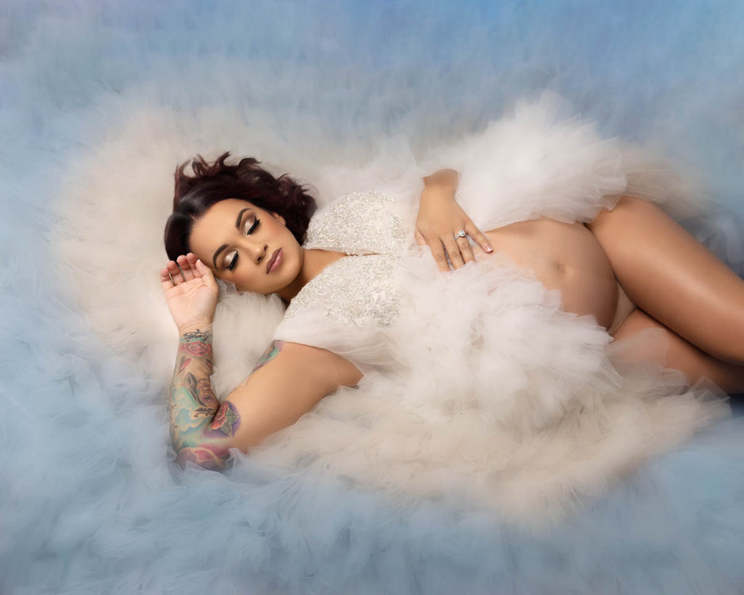 Pregnant woman relaxing in bed of roses, Orlando maternity photographer