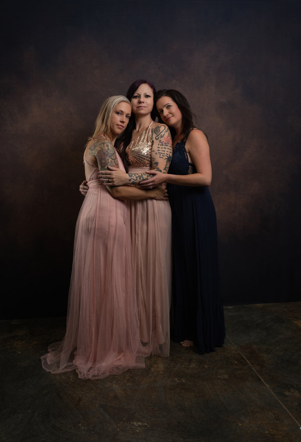 Studio portrait of 3 generations of women with a painted backdrop, portrait created by Heather Johnson Photography