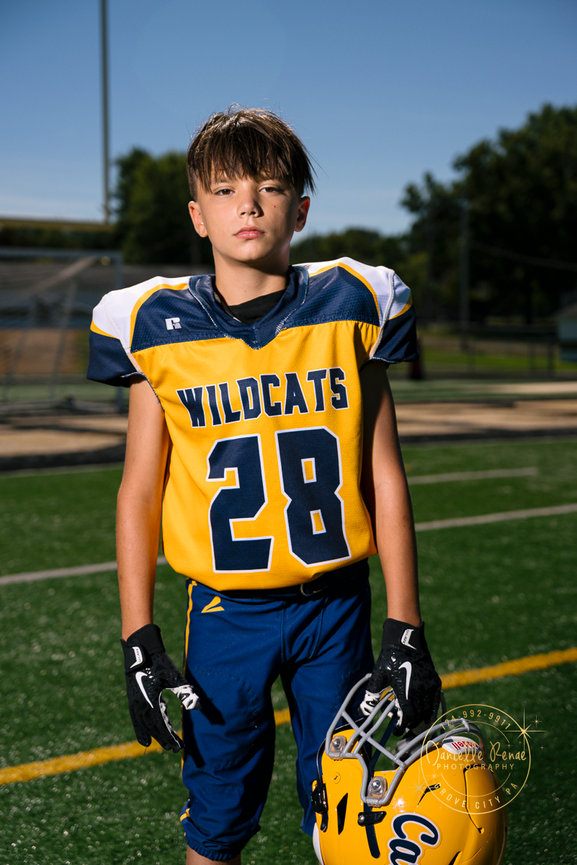 youth football player is standing on the football field
