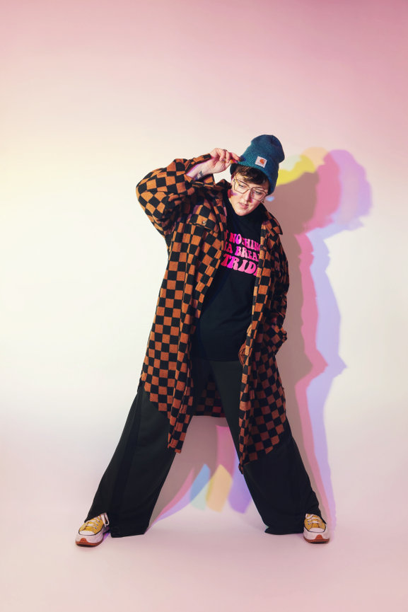 Editorial photo of Iowa photographer, Jaimy Ellis wearing a street style outfit photographed on a white background with multi-colored shadows behind.