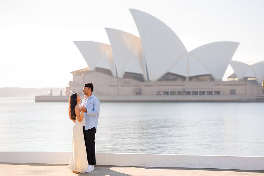Portrait of a couple dancing with the Sydney Opera House behind them.