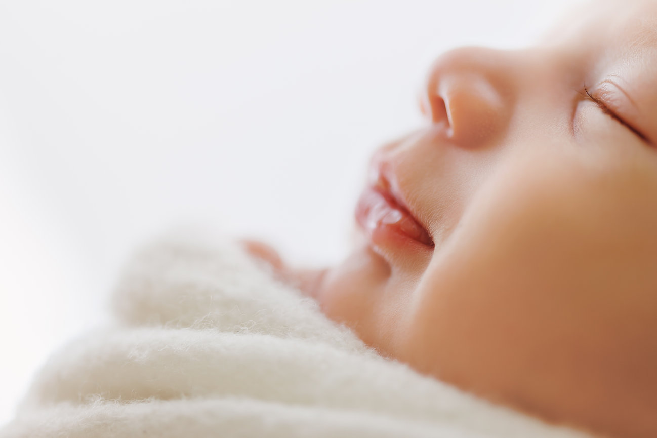 Newborn baby close up, side profile with white background