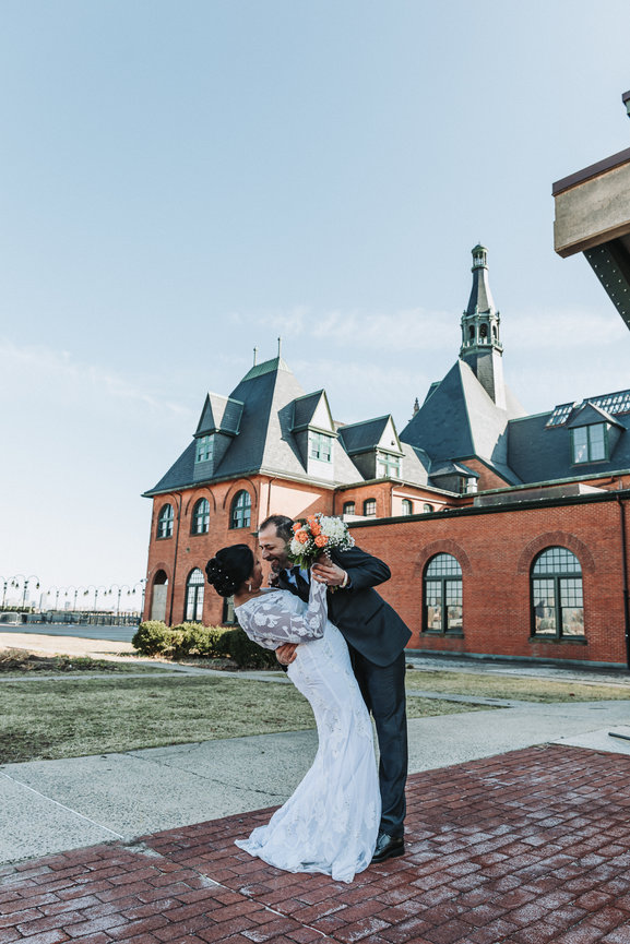 Bride and groom together in front of skyline at liberty State park