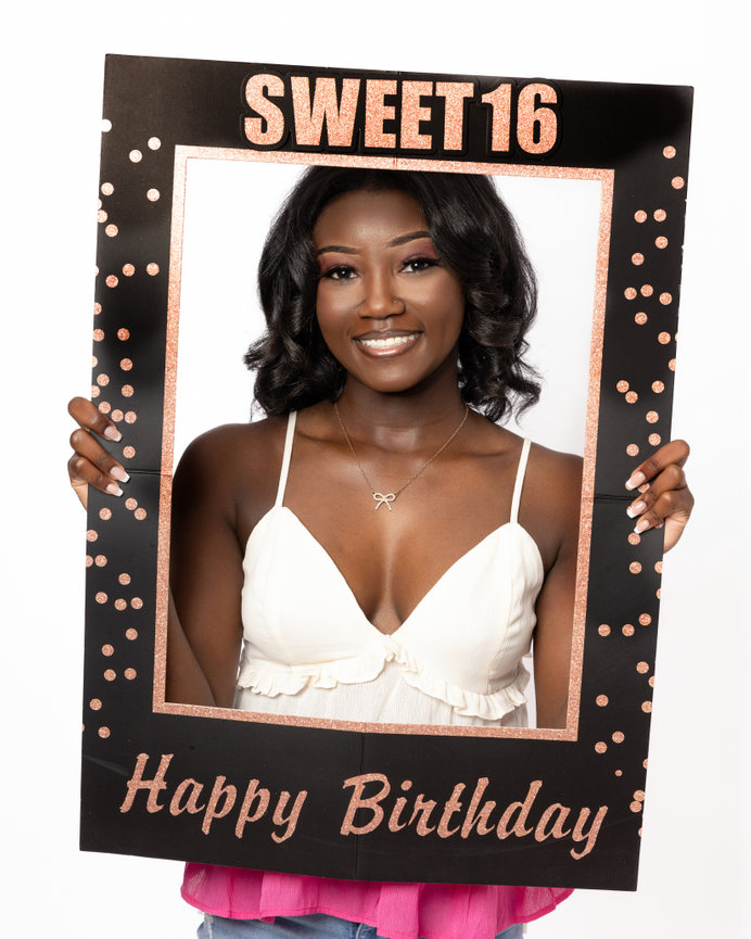 Sweet 16 birthday picture of a girl holding a birthday sign.