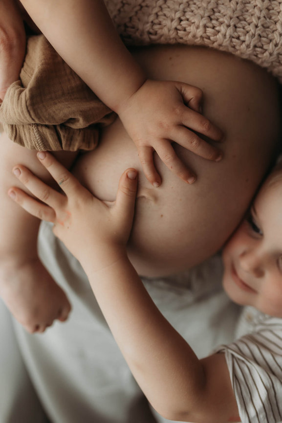 Two boys hands on their pregnant mother's belly captured by a New Jersey Maternity Photographer.