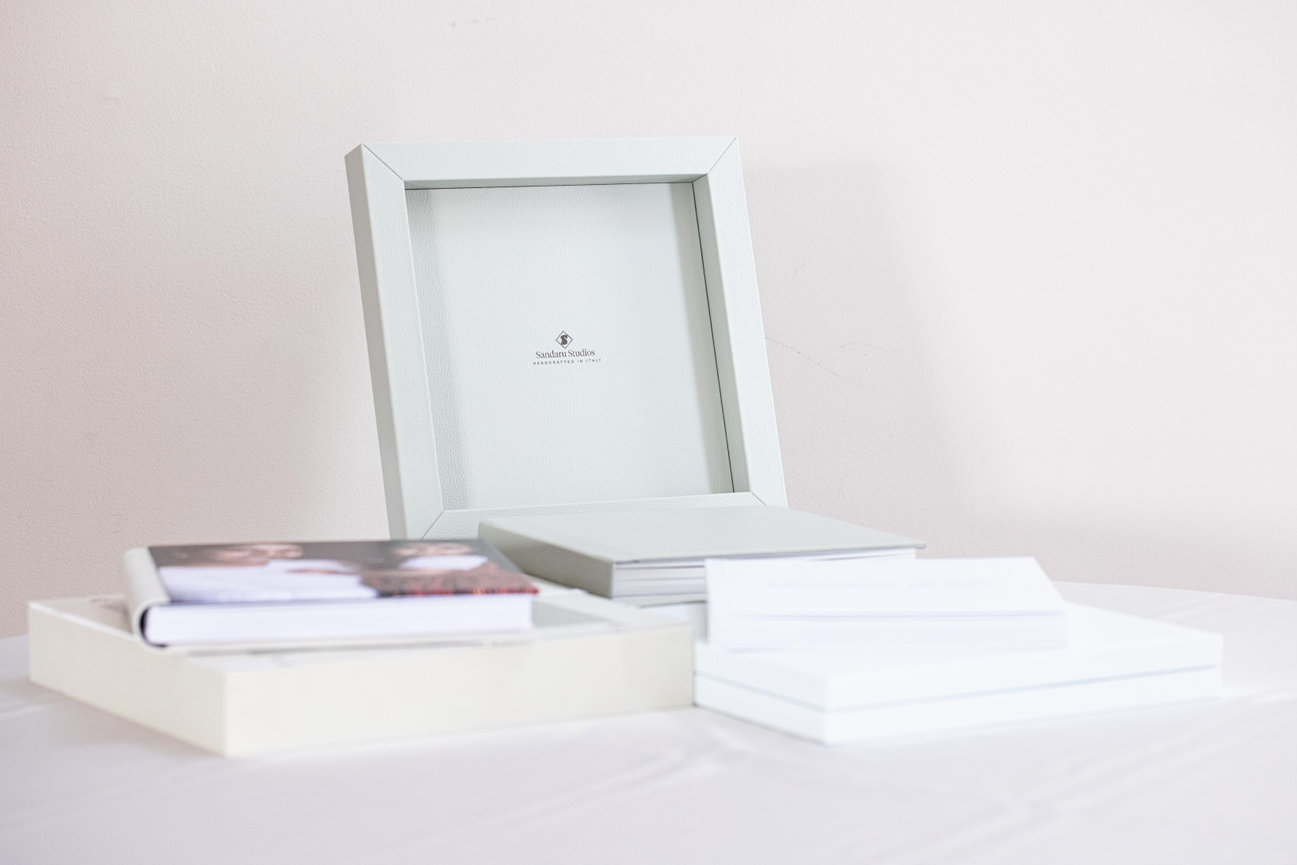 stacked fine art portrait albums displayed with printed photographs in a clean setting