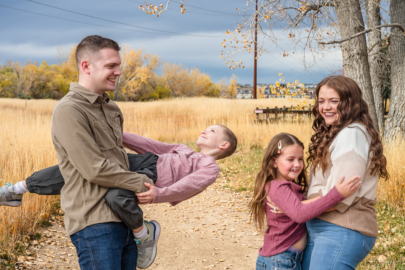Two parents are twirling their children for the giggles.