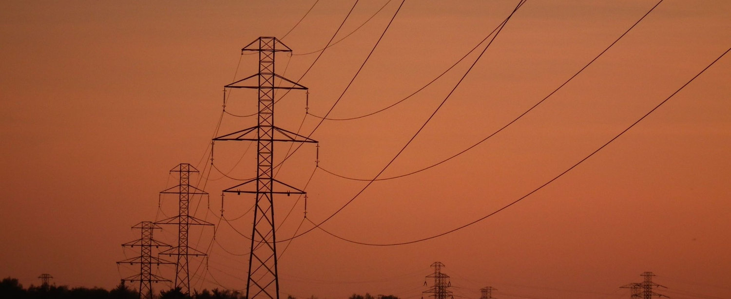 A set of powerlines against a sunset is used as a background image for words of testimonials by professionals in Alberta's utility industry who have worked with Russ Bell as a utility consultant and expert witness.