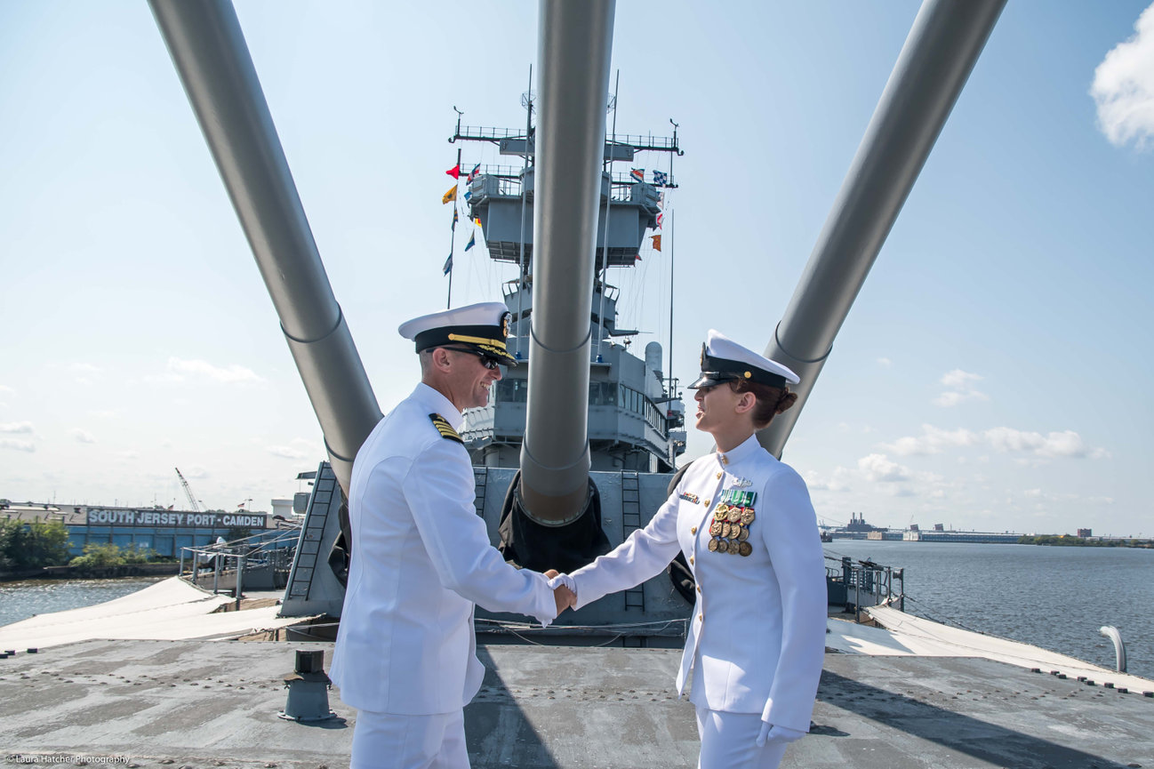 A Naval Officer shaking hands with a Chief on the bow of a Battleship