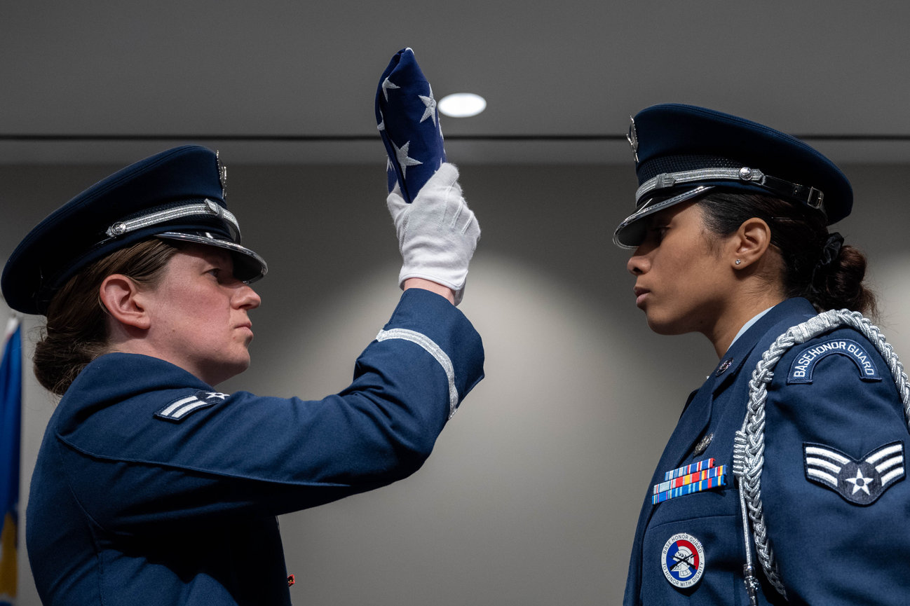 Two Women Air Force enlisted representing the ceremonial guard during a flag folding ceremony