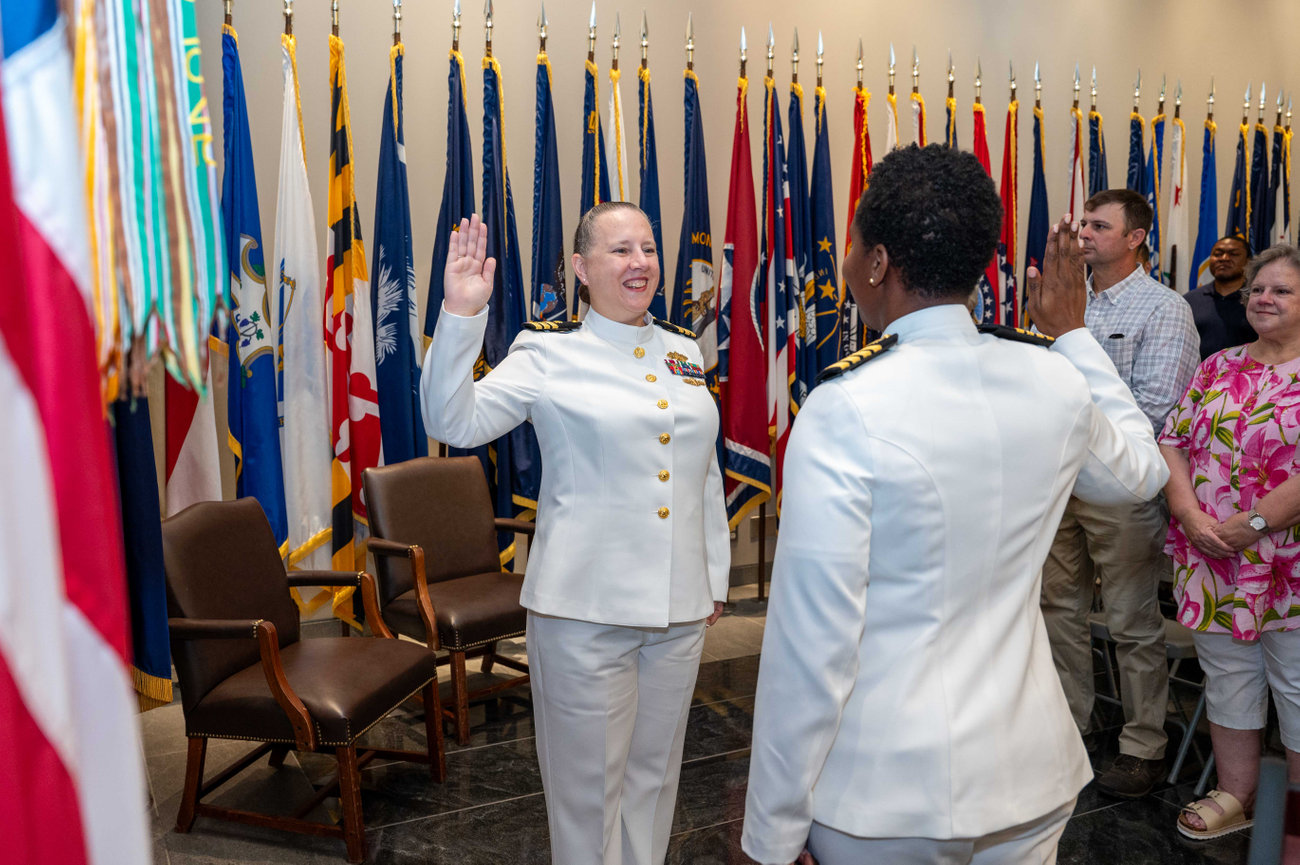 Naval Officer holding up her right hand during the Oath of Office at her promotion ceremony