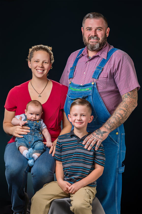Family of four with toddler and infant son posed in the studio.