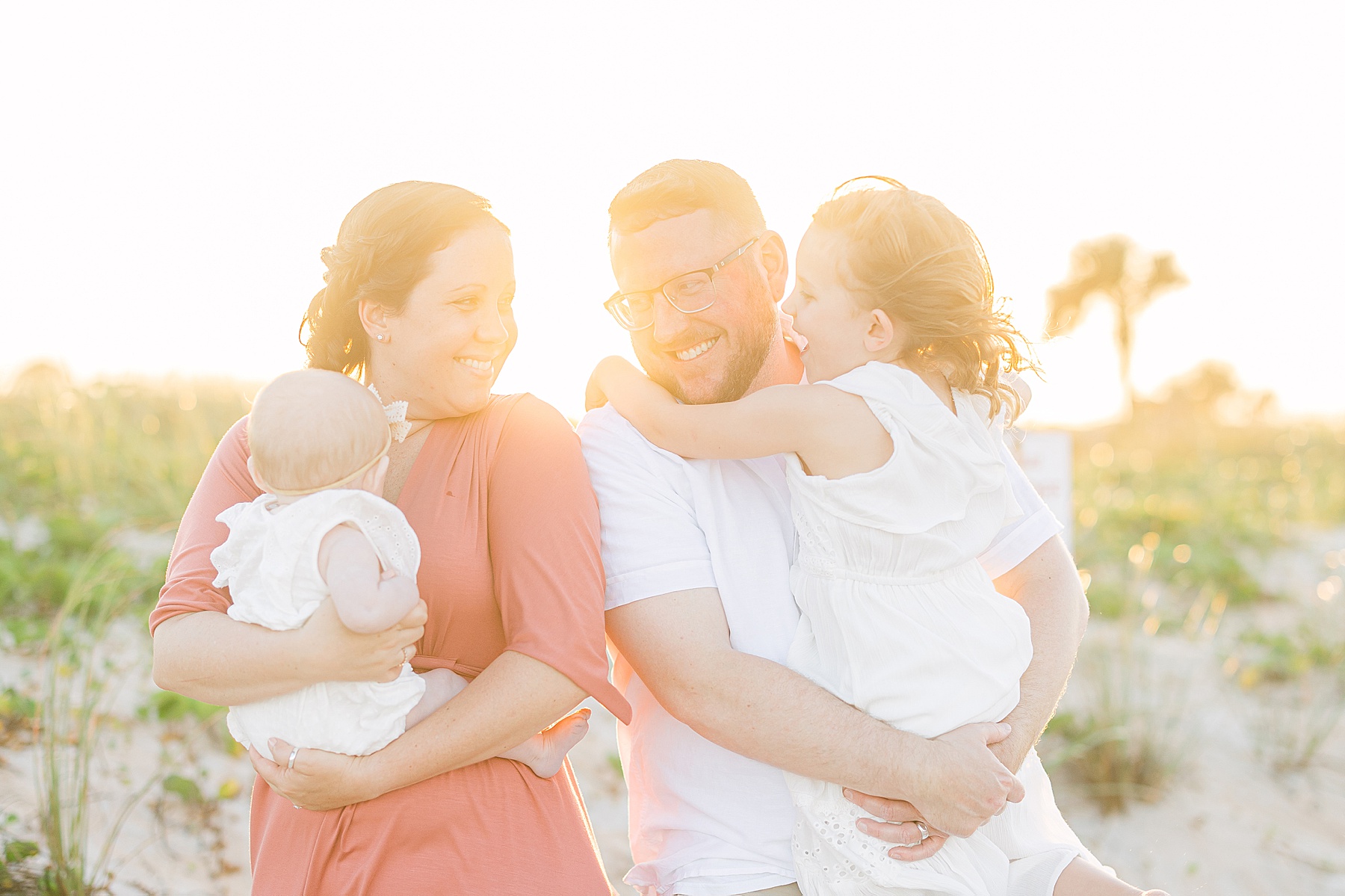family laughing together at the beach light and airy background