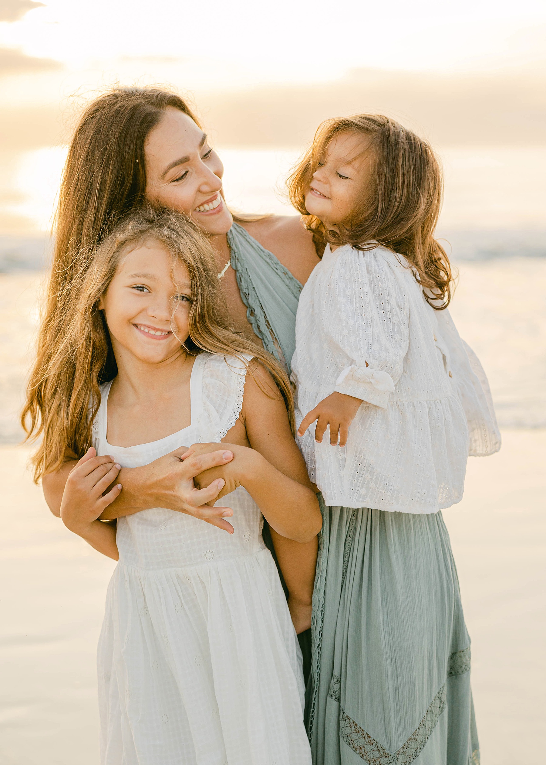 girls standing with mom in long green dress