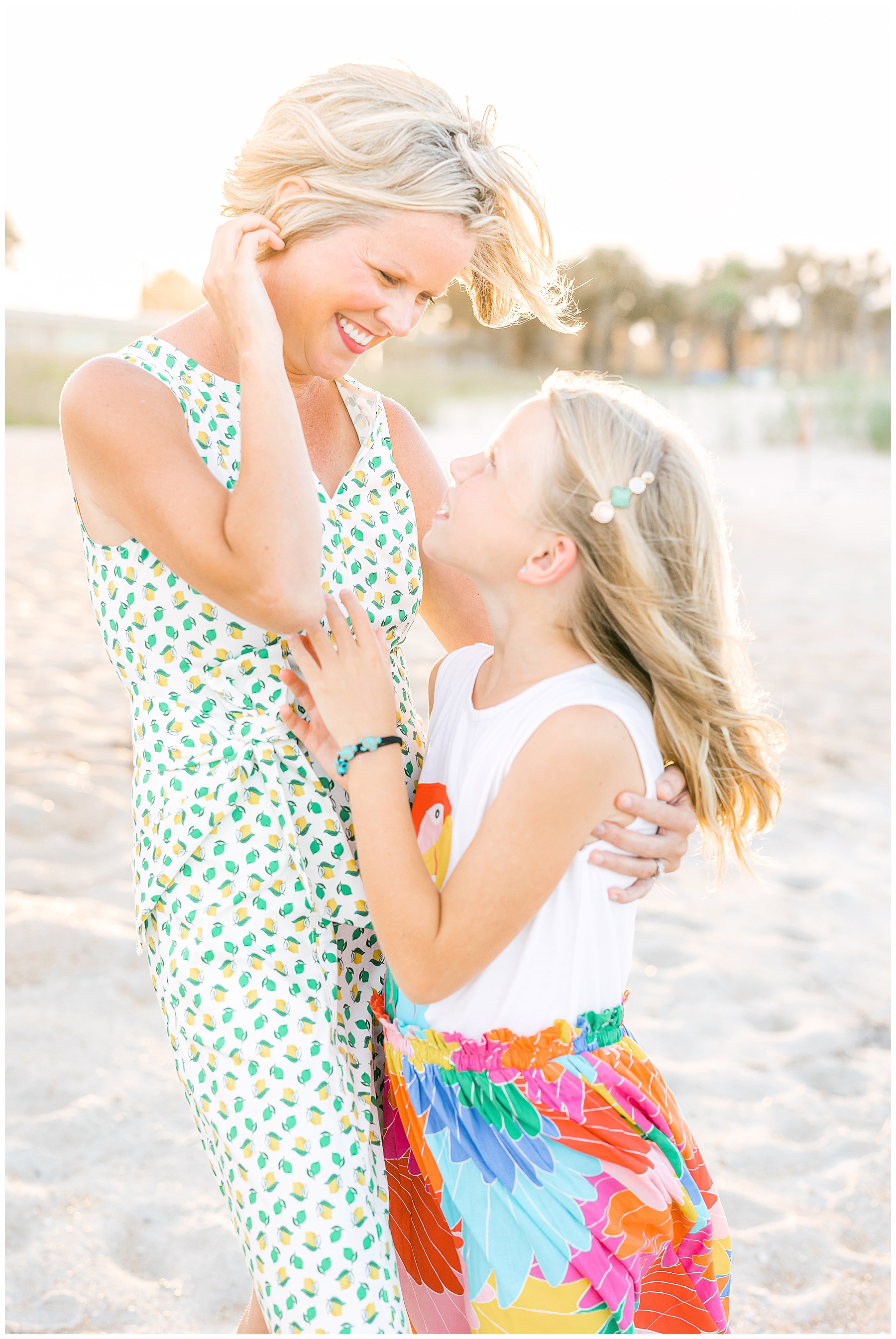 blond haired woman standing with blond haired little girl in brightly colored clothing on the beach in st. augustine florida