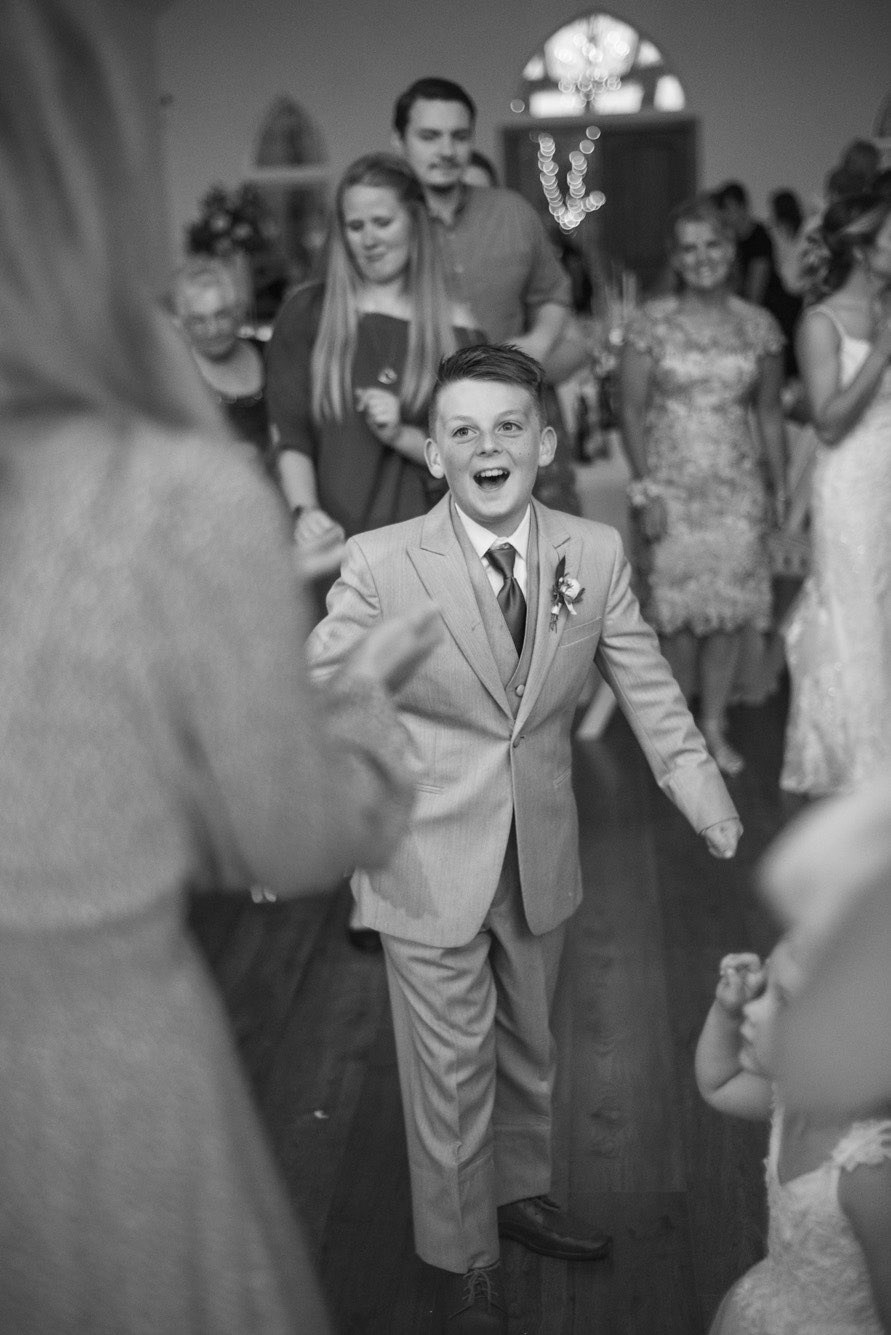 Little boy laughing and dancing at a wedding reception at Dooley's Chapel.