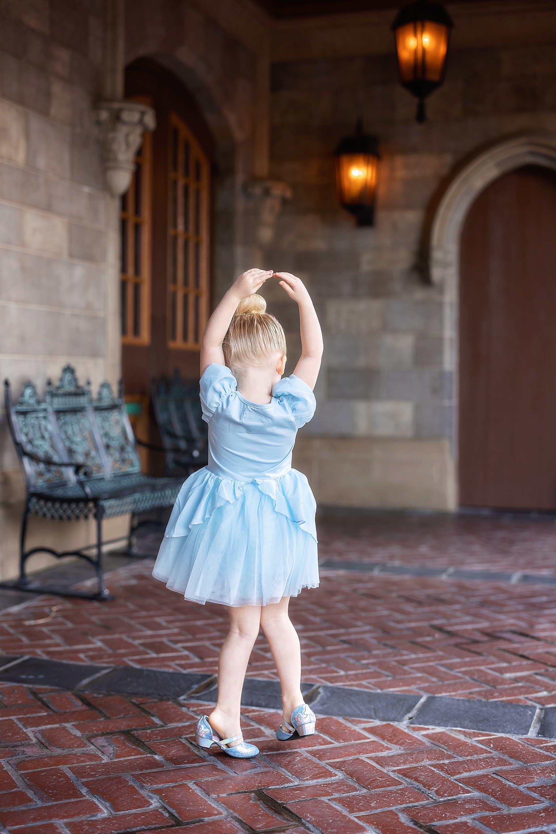 little girl in blue Cinderella dress dancing by Cinderella's castle 