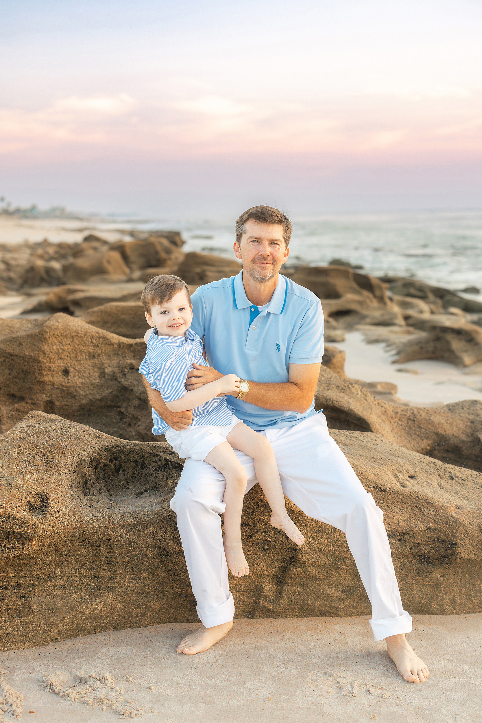 A beach portrait of a father and his son captured by Saint Augustine family photographer, Rya Duncklee of Ryaphotos