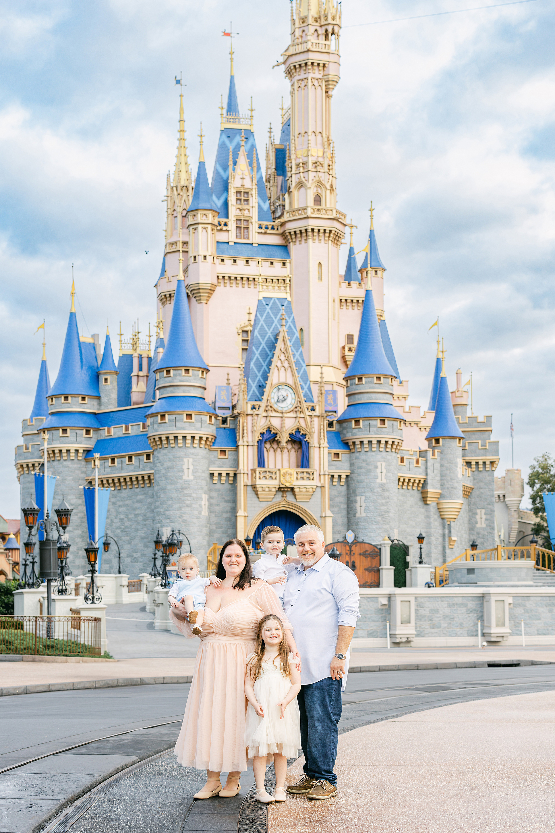 A family of five stands in front of Cinderella's Castle at the Magic Kingdom Park in Orlando, Florida.