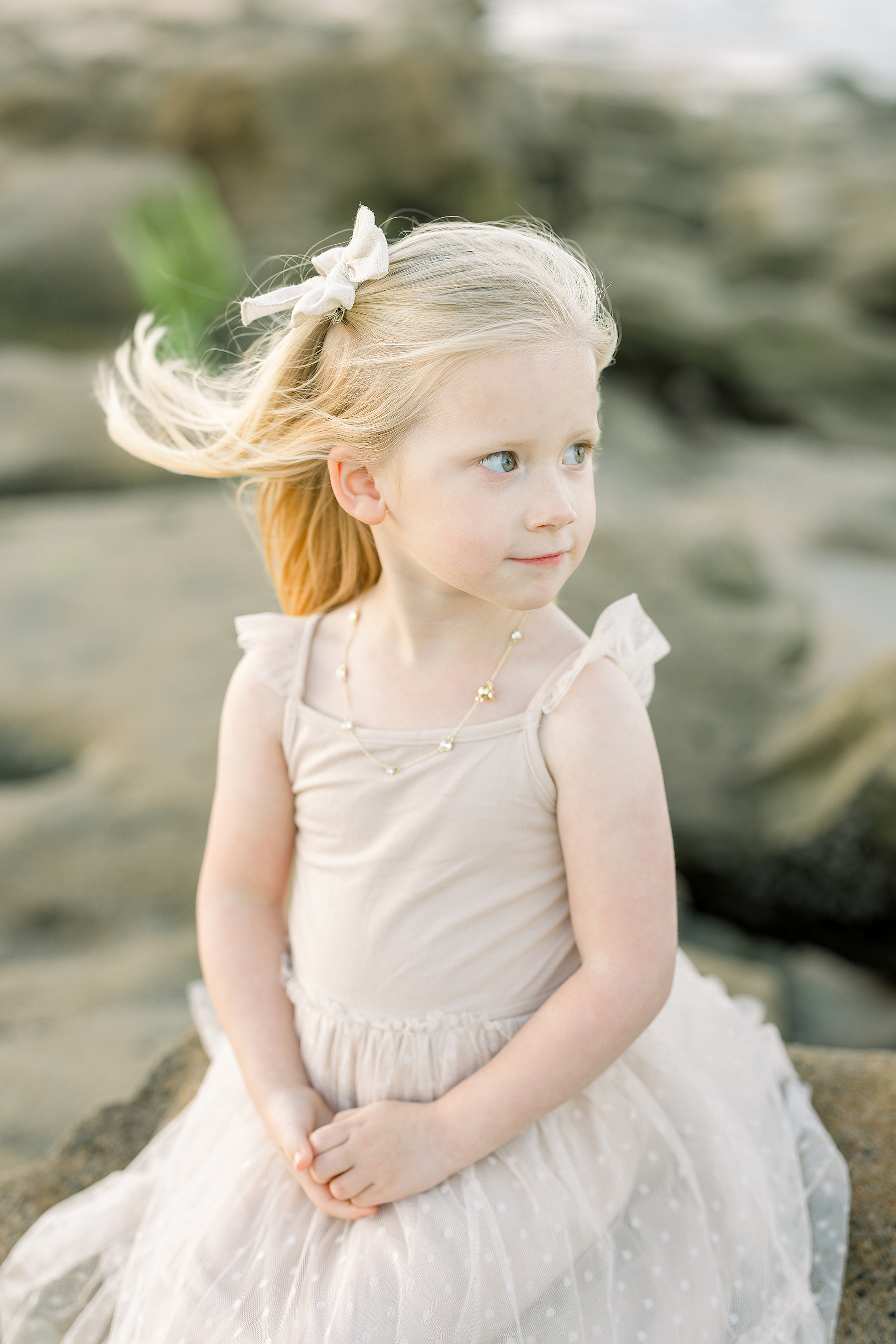 A sunset beach portrait of a little girl in a tan tutu dress on the beach.