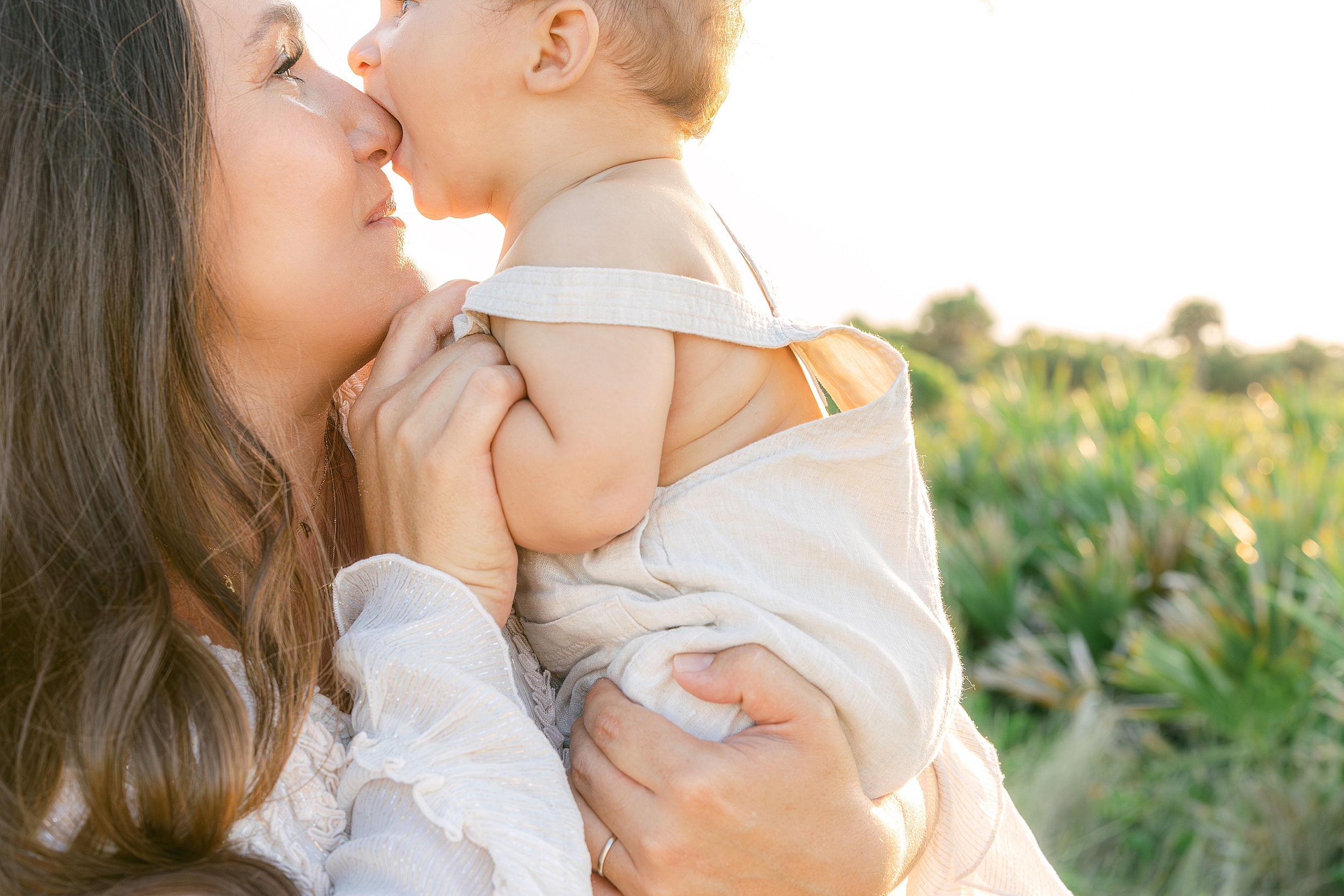 A woman holds her squishy baby boy on the beach at sunset in Saint Augustine, Florida.