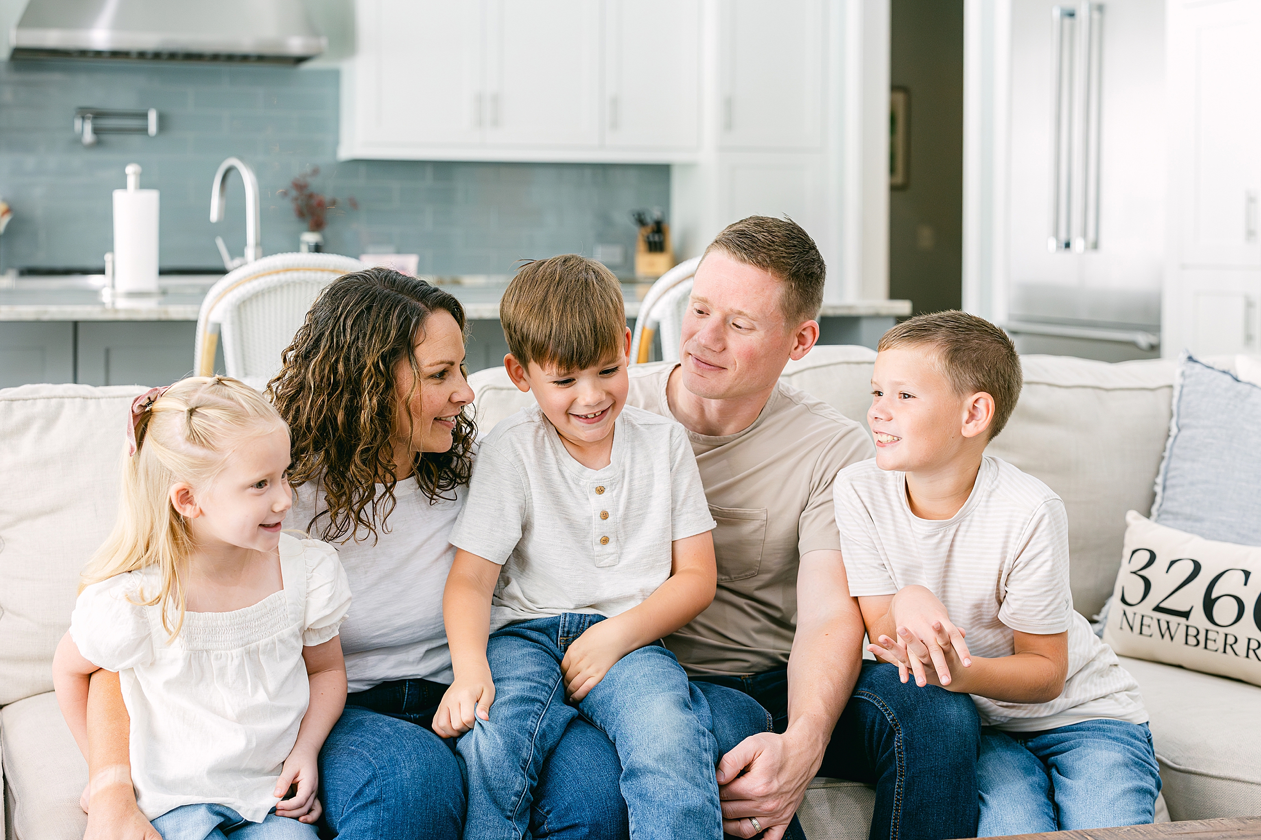 A family sits on their couch during an in-home portrait session in Gainesville, FL.