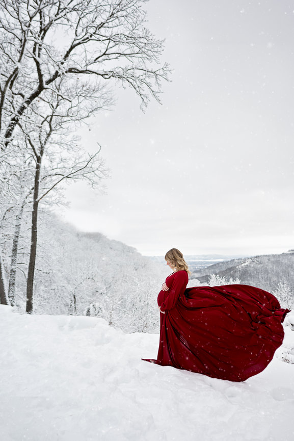 Winter Maternity Photo with a red dress against white snow