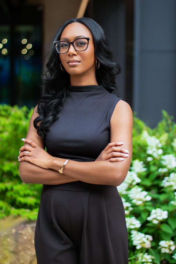 Woman in black attire with glasses in garden setting