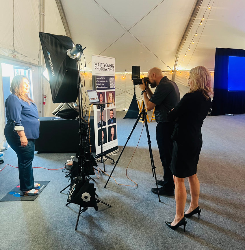 Attendees getting professional LinkedIn headshots at trade show booth in Arizona