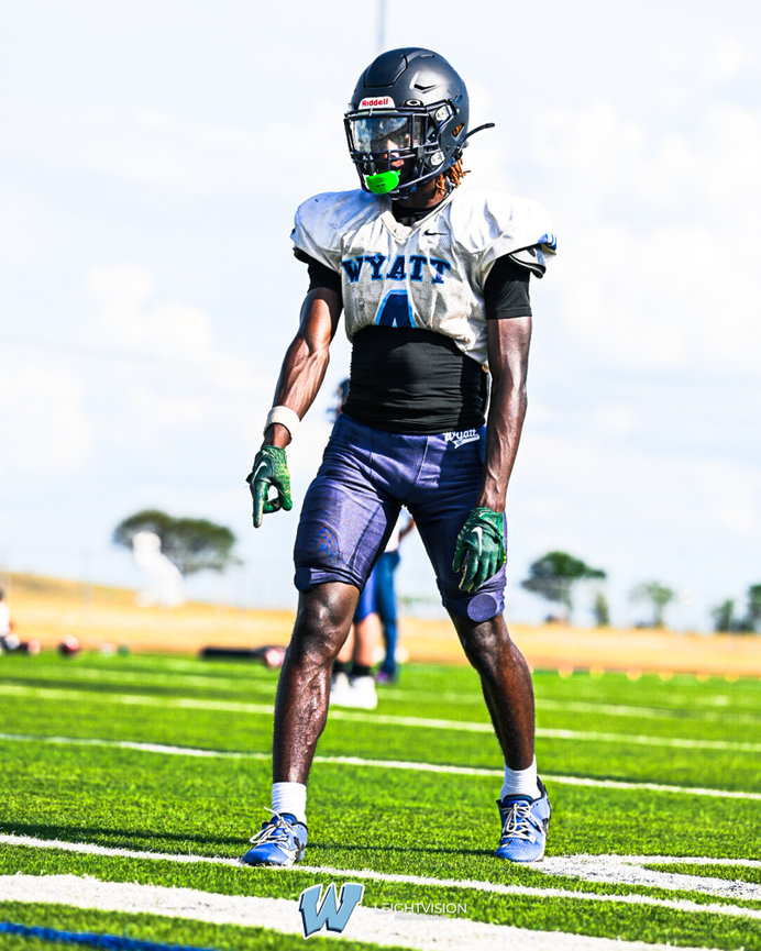A man dressed in a football uniform stands ready for action, embodying the essence of the sport.