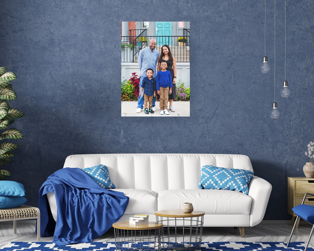 Family of four portrait on a blue wall above the couch
