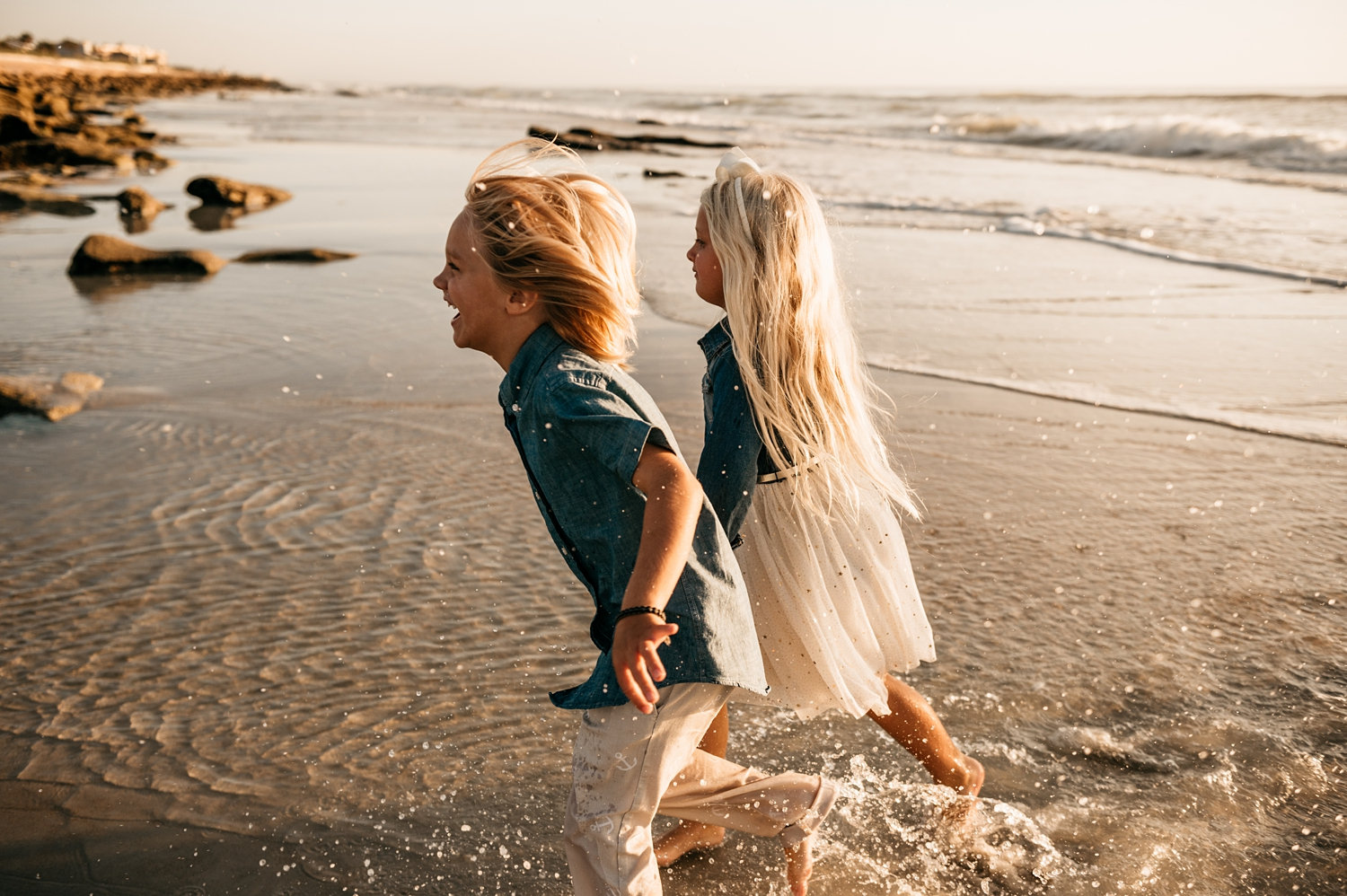 fraternal twins running in the sand and surf along Saint Augustine Beach