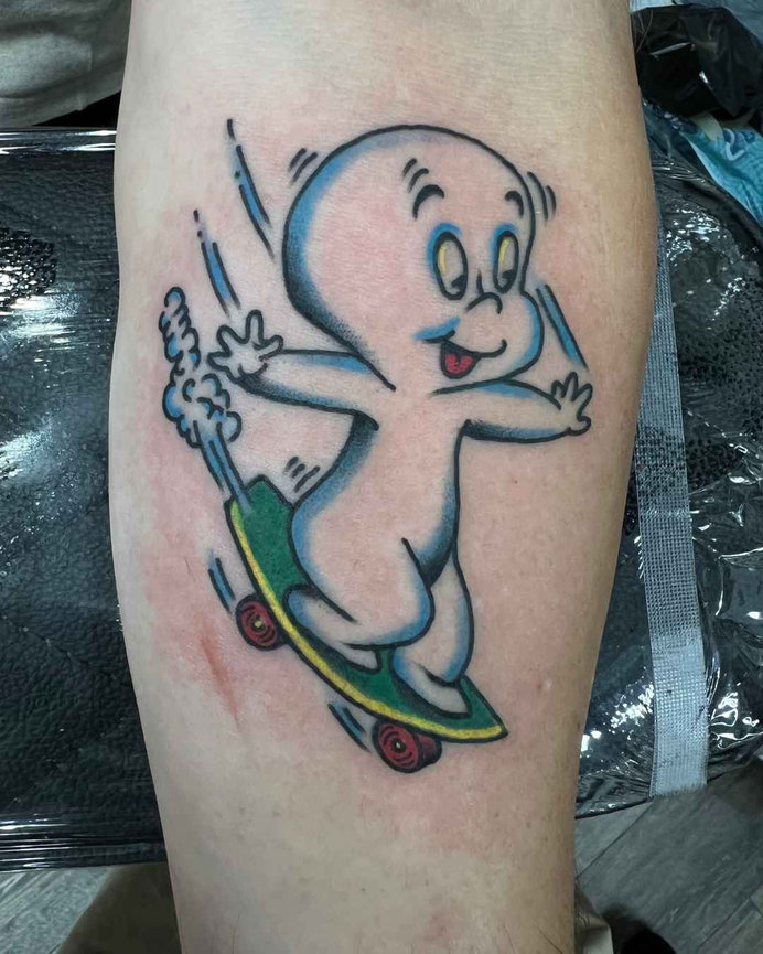 Tattoo of Casper the Friendly Ghost riding a green and yellow skateboard with red wheels mage by Beam at Orange County tattoo shop, Torch Tattoo.