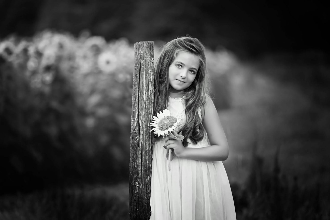 Black and white close-up portrait of a young girl, highlighting soft expression and fine art details.