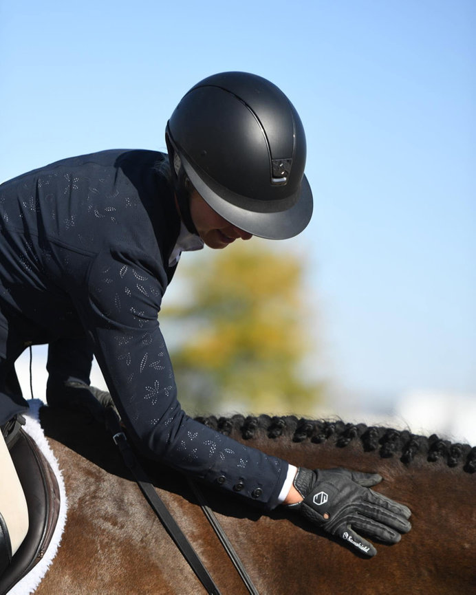 Close-up of an equestrian rider wearing a helmet and gloves.