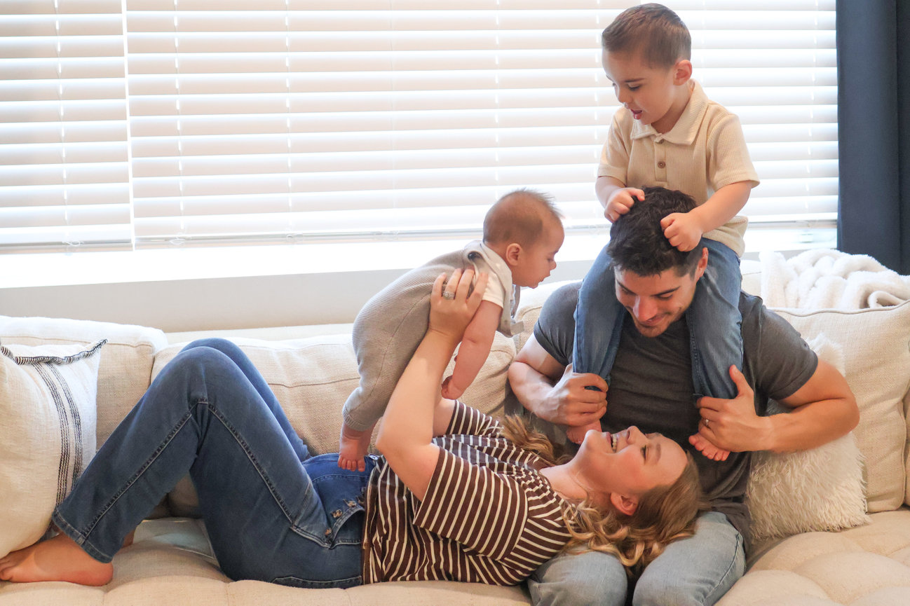 Family relaxing together on a couch with two children
