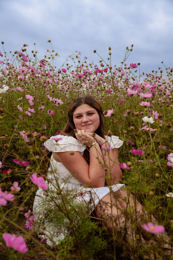 Woman sitting in a field of wildflowers