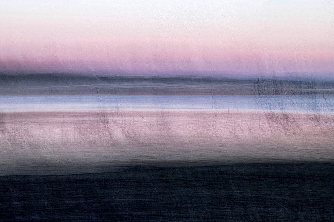 Abstract blurred horizontal streaks in pink, gray, and black tones with a soft gradient.