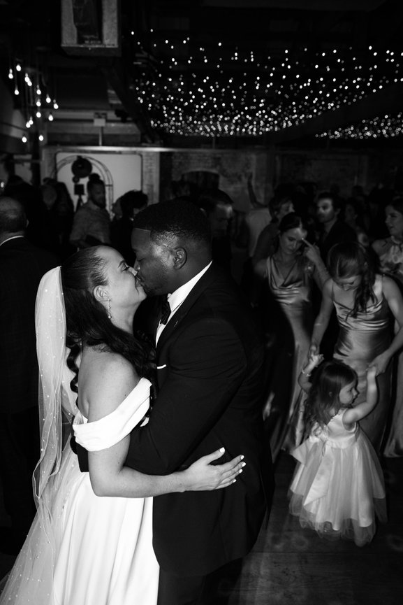 Candid monochrome wedding photography featuring a bride & groom kissing at Lady Grey Farm; captured with a gritty, high-contrast editorial flash aesthetic.