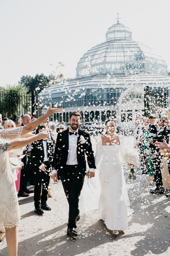 Modern wedding photography: Bride and groom during striking white confetti toss at Sefton Park.