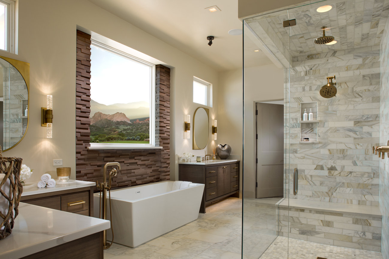 Large Guest bath with free standing tub, beautiful walk in shower with lots of stone and marble with a view of the Garden of Gods Mountains in Colorado Springs.